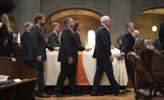Gov. Tim Walz, second from right, walks with Melissa Hortman's casket as it is processed through the aisle in the sanctuary at the Basilica of St. Mary during funeral services for Mark and Melissa Hortman in Minneapolis, Minn., on Saturday, June 28, 2025. (Alex Kormann/Star Tribune via AP, Pool)