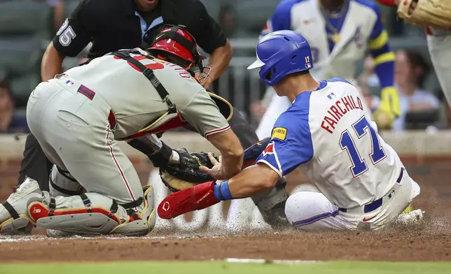 Philadelphia Phillies catcher J.T. Realmuto, left, tags out Atlanta Braves' Stuart Fairchild (17) at the plate in the second inning of a baseball game, Saturday, June 28, 2025, in Atlanta. (AP Photo/Colin Hubbard)