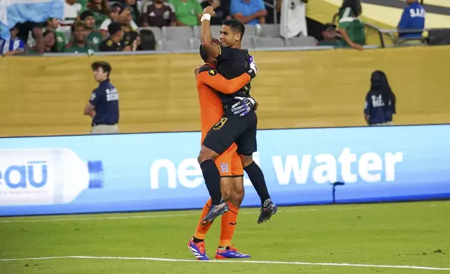 Honduras midfielder Carlos Pineda (19) celebrates scoring the game-winning penalty kick with Honduras goal keeper Edrick Menjivar (1) during a CONCACAF Gold Cup quarterfinal soccer match against Panama, Saturday, June 28, 2025, in Glendale, Ariz. (AP Photo/Samantha Chow)