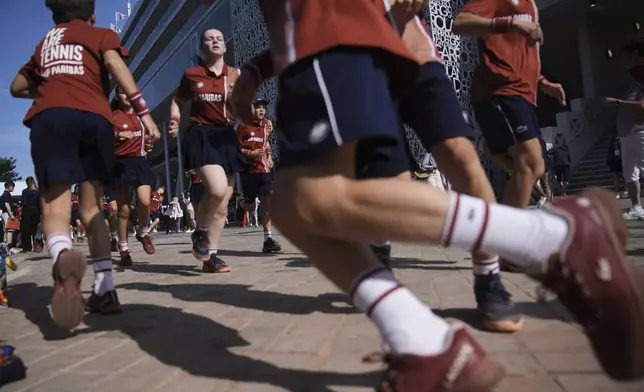Ball boys and girls warm up for the French Tennis Open at the Roland-Garros stadium in Paris, Tuesday, June 3, 2025. (AP Photo/Christophe Ena)