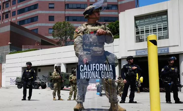 U.S. National Guard stand protect buildings Tuesday, June 10, 2025, in Los Angeles. (AP Photo Damian Dovarganes)