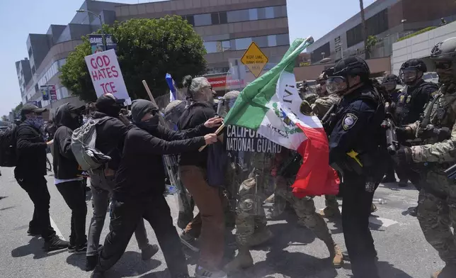 Protesters clash with authorities in downtown Los Angeles, Sunday, June 8, 2025, following last night's immigration raid protest. (AP Photo/Jae Hong)
