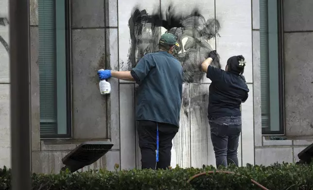 Workers remove graffiti from the Ronald Reagan Federal Building and Courthouse in Santa Ana, Calif., Tuesday, June 10, 2025, after Monday's protests against President Trump's ICE raids resulted in violence. (Mindy Schauer/The Orange County Register via AP)