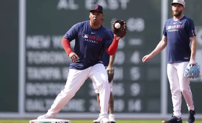 Boston Red Sox designated hitter Rafael Devers, center, takes infield practice with teammates prior to a baseball game against the Tampa Bay Rays at Fenway Park, Wednesday, June 11, 2025, in Boston. (AP Photo/Charles Krupa)