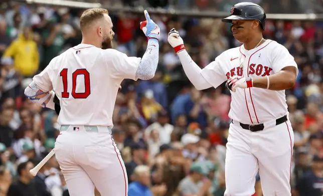 Boston Red Sox's Rafael Devers, right, celebrates with shortstop Trevor Story (10) after hitting a solo home run in the fifth inning of a baseball game against the New York Yankees, Sunday, June 15, 2025, in Boston. (AP Photo/Greg M. Cooper)