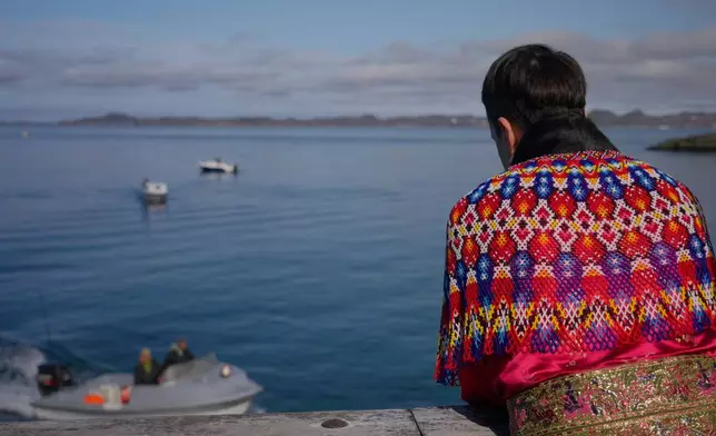 Local wearing a traditional clothing made of pearl collar and seal hides watch the seal hunting competition in Nuuk, Greenland (AP Photo/Kwiyeon Ha)