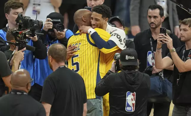 Indiana Pacers guard Tyrese Haliburton hugs NBA hall of fame Reggie Miller, left, after Game 6 of the NBA Finals basketball series against the Oklahoma City Thunder, Thursday, June 19, 2025, in Indianapolis. (AP Photo/Michael Conroy)