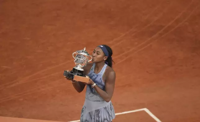 Winner Coco Gauff of the U.S. kisses the trophy after the final match of the French Tennis Open against Aryna Sabalenka of Belarus at the Roland-Garros stadium in Paris, Saturday, June 7, 2025. (AP Photo/Christophe Ena)
