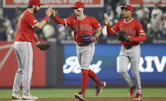 Los Angeles Angels' Nolan Schanuel, left, Zach Neto, center, and Christian Moore, right, react after defeating the New York Yankees during a baseball game Tuesday, June 17, 2025, in New York. (AP Photo/Pamela Smith)
