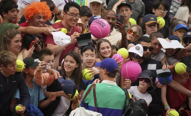 Italy's Jannik Sinner signs autographs to fans after beating Jiri Lehecka of the Czech Republic during their third round match of the French Tennis Open, at the Roland-Garros stadium, in Paris, Saturday, May 31, 2025. (AP Photo/Thibault Camus)
