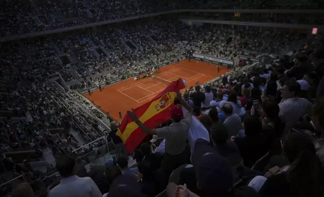 A fan holds Spain's flag during the quarterfinal match of the French Tennis Open between Tommy Paul of the U.S. and Spain's Carlos Alcaraz at the Roland-Garros stadium in Paris, Tuesday, June 3, 2025. (AP Photo/Thibault Camus)
