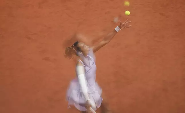 China's Qinwen Zheng is reflected on a glass as she serves against Aryna Sabalenka of Belarus during their quarterfinal match of the French Tennis Open at the Roland-Garros stadium in Paris, Tuesday, June 3, 2025. (AP Photo/Aurelien Morissard)