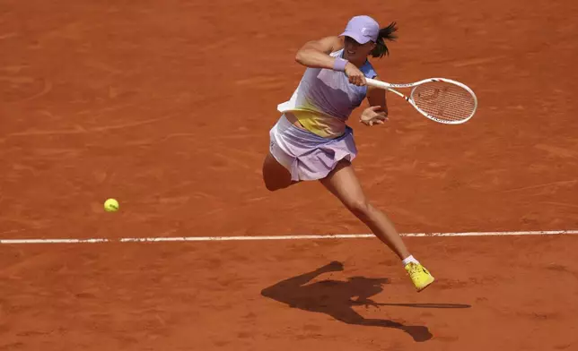 Poland's Iga Swiatek plays a shot against Ukraine's Elina Svitolina during their quarterfinal match of the French Tennis Open at the Roland-Garros stadium in Paris, Tuesday, June 3, 2025. (AP Photo/Aurelien Morissard)