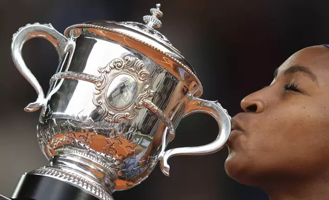 Coco Gauff of the U.S. kisses the trophy as she won the final match of the French Tennis Open against Aryna Sabalenka of Belarus at the Roland-Garros stadium in Paris, Saturday, June 7, 2025. (AP Photo/Aurelien Morissard)