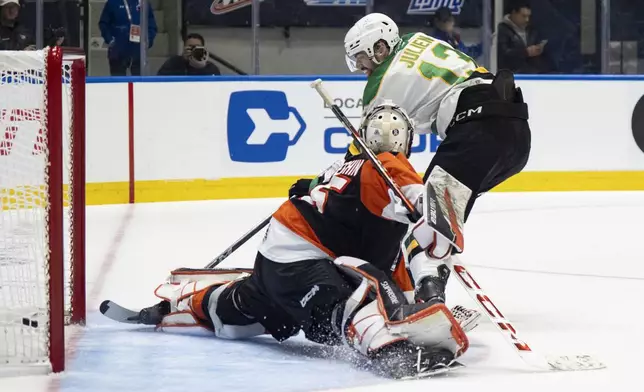 London Knights' Jacob Julien (13) scores against Medicine Hat Tigers goaltender Harrison Meneghin, left, during first-period Memorial Cup final hockey game action in Rimouski, Quebec, Sunday, June 1, 2025. (Christopher Katsarov/The Canadian Press via AP)
