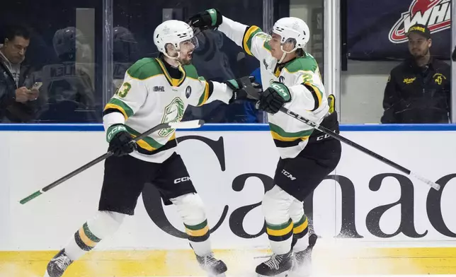 London Knights' Jacob Julien (13) celebrates with Henry Brzustewicz (2) after scoring against Medicine Hat Tigers goaltender Harrison Meneghin during first-period Memorial Cup final hockey game action in Rimouski, Quebec, Sunday, June 1, 2025. (Christopher Katsarov/The Canadian Press via AP)