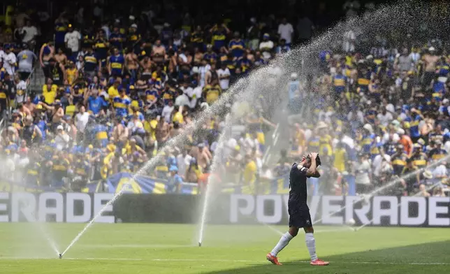 Auckland City's Gerard Garriga cools off under the sprinklers during a water break in the Club World Cup Group C soccer match between Auckland City and Boca Juniors in Nashville, Tenn., Tuesday, June 24, 2025. (AP Photo/George Walker IV)