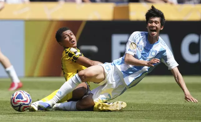 Borussia Dortmund's Jobe Bellinghamm, background, stops Ulsan HD's Kim Min-hyeok during the Club World Cup Group F soccer match between Borussia Dortmund and Ulsan in Cincinnati, Wednesday, June 25, 2025. (AP Photo/Jeff Dean)