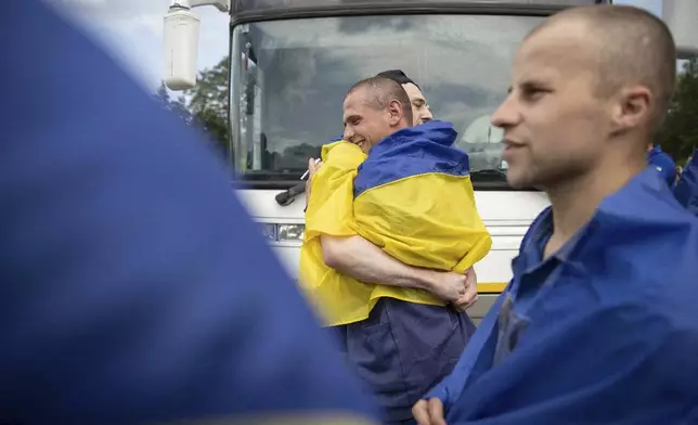 In this photo provided by the Ukrainian Presidential Press Office, Ukrainian soldiers react after returning from captivity during a prisoners' exchange between Russia and Ukraine, in Chernyhiv region, Ukraine, Monday, June 9, 2025. (Ukrainian Presidential Press Office via AP)