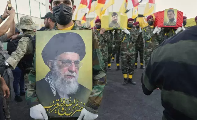 Members from the Popular Mobilization Forces carrying the coffins of Iraqi commander Haider al-Moussawi from Kataeb Sayyed Al-Shuhada and Hussein Khalil, a former aide to the late Hezbollah Secretary-General Hassan Nasrallah that killed by an Israeli airstrike inside Iran, in Baghdad, Iraq, Sunday, June 22, 2025. (AP Photo/Hadi Mizban)