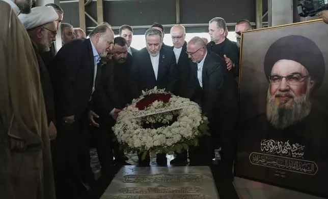 Iranian Foreign Minister Abbas Araghchi, center, lays a wreath at the tomb of slain Hezbollah leader Hassan Nasrallah in the southern suburbs of Beirut, Lebanon, Tuesday, June 3, 2025. (AP Photo/Hassan Ammar)