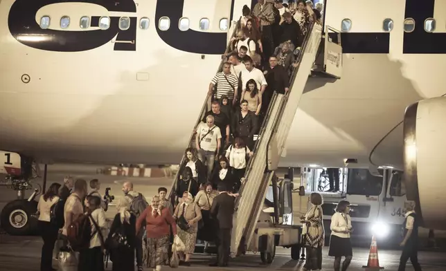 The first group of Bulgarian citizens evacuated from Israel, along with dozens of foreign nationals from Slovenia, the U.S., Belgium, Albania, Kosovo and Romania, arrive at Vassil Levsky airport in Sofia, Wednesday, June 18, 2025. (AP Photo/Valentina Petrova)