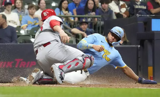 Milwaukee Brewers' Jackson Chourio, right, scores against St. Louis Cardinals catcher Pedro Pagés, left, on a single by Brewers' Christian Yelich during the sixth inning of a baseball game Friday, June 13, 2025, in Milwaukee. (AP Photo/Kayla Wolf)