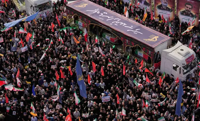 Mourners gather around the flag-draped coffins of the Iranian armed forces generals, nuclear scientists and their family members on the trucks, who were killed in Israeli strikes, during their funeral ceremony in Tehran, Iran, Saturday, June 28, 2025. (AP Photo/Vahid Salemi)