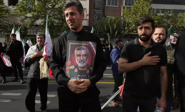 A man holds a picture of Iran's late head of the Revolutionary Guard’s ballistic missile program, Gen. Amir Ali Hajizadeh during the funeral ceremony of him, some other Iranian armed forces generals, nuclear scientists and their family members, who were killed in a 12-day war with Israel, in Tehran, Iran, Saturday, June 28, 2025. (AP Photo/Vahid Salemi)
