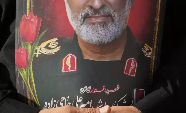 A man holds a picture of Iran's late head of the Revolutionary Guard’s ballistic missile program, Gen. Amir Ali Hajizadeh during the funeral ceremony of him, some other Iranian armed forces generals, nuclear scientists and their family members, who were killed in a 12-day war with Israel, in Tehran, Iran, Saturday, June 28, 2025. (AP Photo/Vahid Salemi)