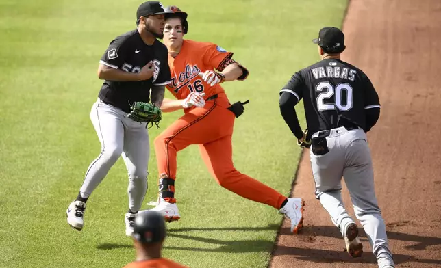Baltimore Orioles' Coby Mayo (16) is caught in a rundown by Chicago White Sox first baseman Miguel Vargas (20) and second baseman Lenyn Sosa (50) during the fourth inning of a baseball game, Saturday, May 31, 2025, in Baltimore. (AP Photo/Nick Wass)
