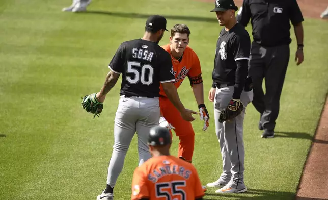 Chicago White Sox second baseman Lenyn Sosa (50) gestures to Baltimore Orioles' Coby Mayo, second from upper left, after Mayo was caught in a rundown during the fourth inning of a baseball game, Saturday, May 31, 2025, in Baltimore. (AP Photo/Nick Wass)
