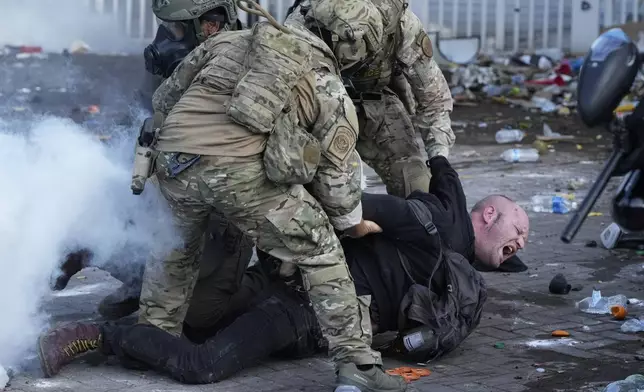 U.S. Customs and Border Protection agents detain a man outside the U.S. Immigration and Customs building during a protest Saturday, June 14, 2025, in Portland, Ore. (AP Photo/Jenny Kane)