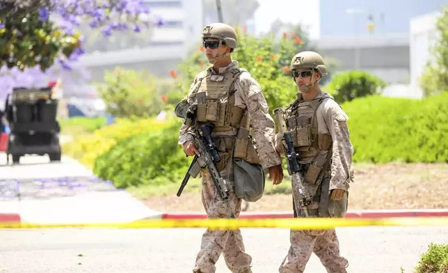 U.S Marines work outside of a federal building, Friday, June 13, 2025, in Los Angeles (AP Photo/Noah Berger)
