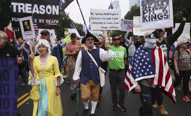 Demonstrators dressed in Revolutionary War era clothing march down Benjamin Franklin Parkway during the "No Kings" protest, Saturday, June 14, 2025, in Philadelphia. (AP Photo/Yuki Iwamura)