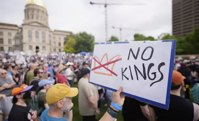 A demonstrator holds a sign during a "No Kings" protest, Saturday, June 14, 2025, in Atlanta. (AP Photo/Mike Stewart)
