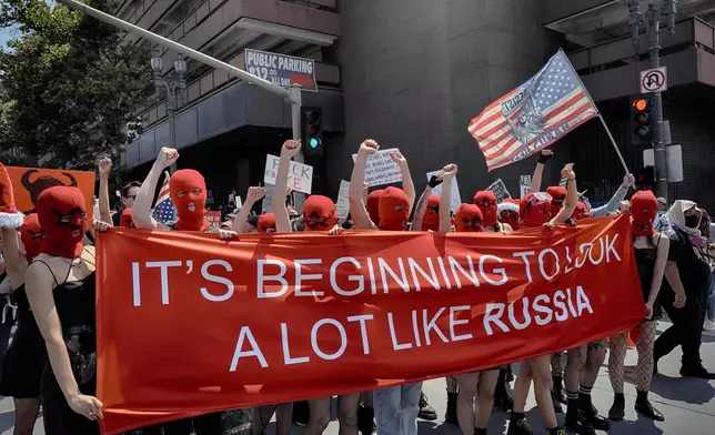 Protesters carry a sign referring to Russia during a "No Kings" protest in downtown Los Angeles on Saturday, June 14, 2025. (AP Photo/Richard Vogel)