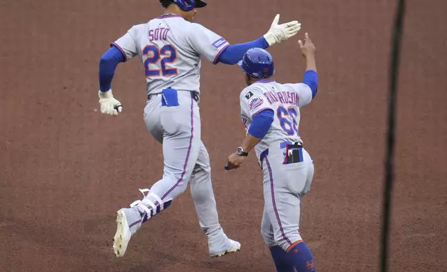 New York Mets' Juan Soto (22) celebrates with first base coach Antoan Richardson (66) as he rounds first after hitting a solo home run off Pittsburgh Pirates pitcher Mitch Keller during the fifth inning of a baseball game in Pittsburgh, Friday, June 27, 2025. (AP Photo/Gene J. Puskar)