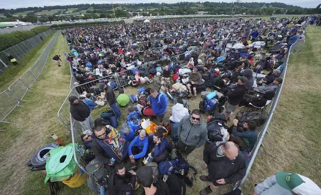 Revellers queue for entry, on the first day of the Glastonbury Festival at Worthy Farm, in Somerset. England, Wednesday June 25, 2025. (Yui Mok/PA via AP)