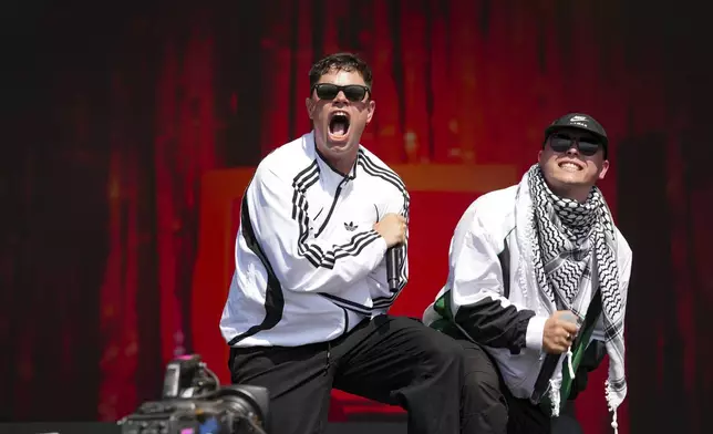 Naoise O Caireallain, left, and Liam Og of the hip hop trio Kneecap perform during the Glastonbury Festival in Worthy Farm, Somerset, England, Saturday, June 28, 2025. (Scott A Garfitt/Invision/AP)