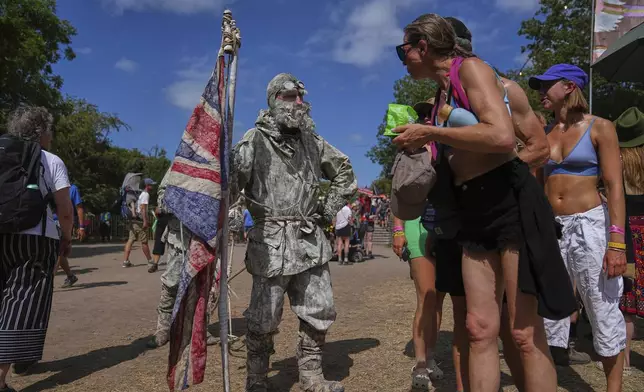 A festivalgoer dressed as an explorer makes his way through the Glastonbury Festival in Worthy Farm, Somerset, England, Thursday, June 26, 2025. (Scott A Garfitt/Invision/AP)