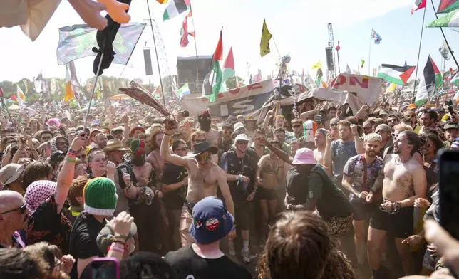 A mosh pit forms during the hip hop trio Kneecap's performance during the Glastonbury Festival in Worthy Farm, Somerset, England, Saturday, June 28, 2025. (Scott A Garfitt/Invision/AP)