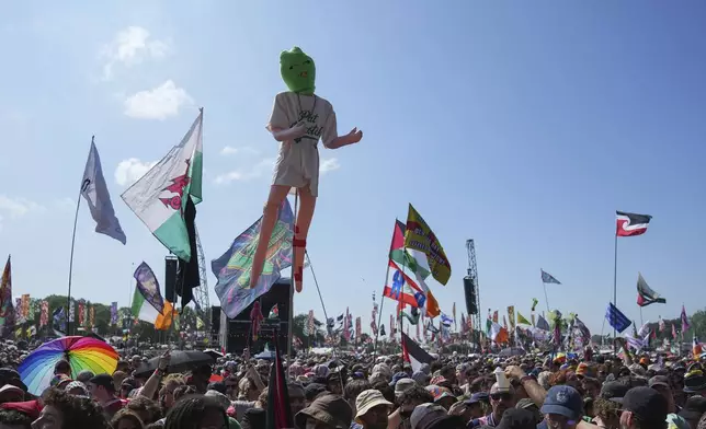 Festivalgoers wait for hip hop trio Kneecap to perform during the Glastonbury Festival in Worthy Farm, Somerset, England, Saturday, June 28, 2025. (Scott A Garfitt/Invision/AP)