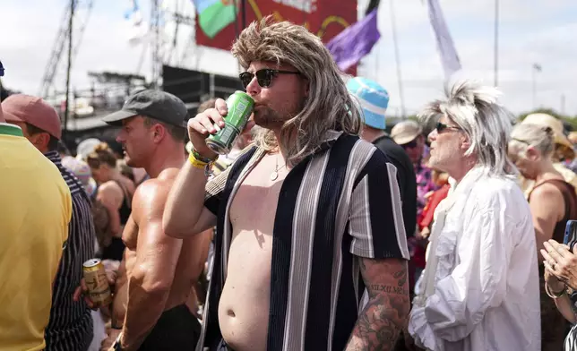 A festivalgoer dressed in Rod Stewart wig waits for Rod Stewart to perform during the Glastonbury Festival in Worthy Farm, Somerset, England, Sunday, June 29, 2025. (Scott A Garfitt/Invision/AP)
