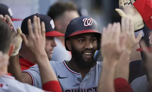 Washington Nationals' Amed Rosario celebrates with teammates in the dugout after hitting a home run during the first inning of a baseball game against the Los Angeles Dodgers in Los Angeles, Friday, June 20, 2025. (AP Photo/Jessie Alcheh)