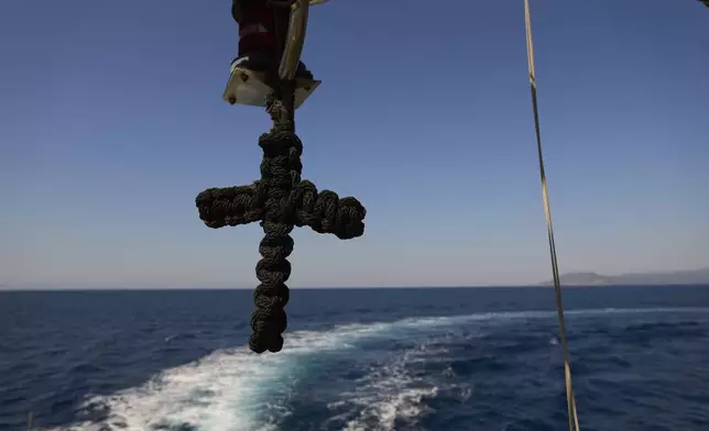 A cross hangs on a Greek coast guard vessel during a patrol in the Aegean Sea between the Greek island of Lesbos and Turkey, Tuesday, May 13, 2025. (AP Photo/Petros Giannakouris)