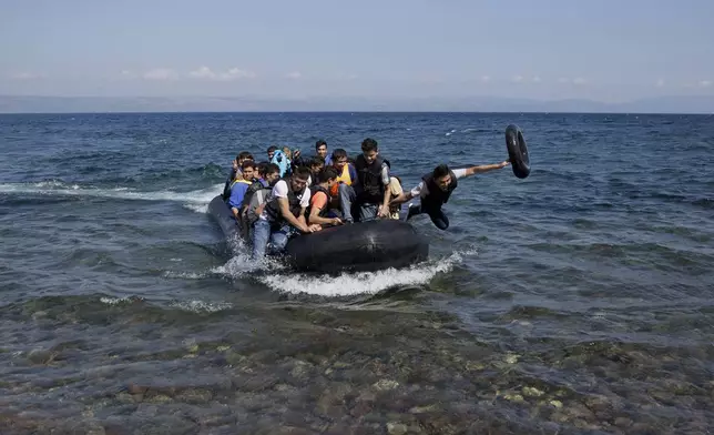 FILE - Afghan migrants arrive on the shores of the Greek island of Lesbos after crossing the Aegean sea from Turkey on a inflatable dinghy, Friday, Sept. 25, 2015. (AP Photo/Petros Giannakouris, File)
