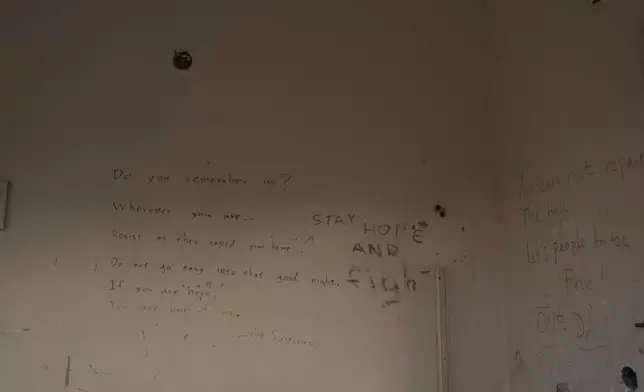 Messages scrawled on the wall of a building in the remains of the former Moria refugee camp, which was destroyed by a massive fire on 2020, are seen on the island of Lesbos, Greece, Monday, May 12, 2025. (AP Photo/Petros Giannakouris)