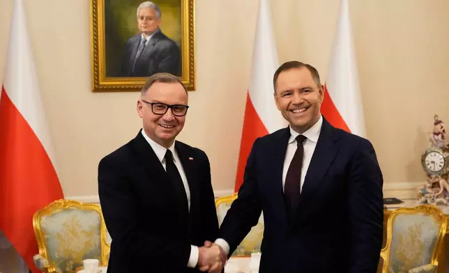 Poland's outgoing President Andrzej Duda, left, welcomes the President Elect Karol Nawrocki at the Presidential Palace in Warsaw, Poland, Tuesday, June 3, 2025. (AP Photo/Czarek Sokolowski)