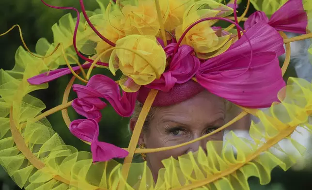 Vivienne Jenner wears a large ribbon based hat as she poses for photographers on the third day of the Royal Ascot horse race meeting, traditionally called Ladies Day, at Ascot, England, Thursday, June 19, 2025. (AP Photo/kKn Cheung)